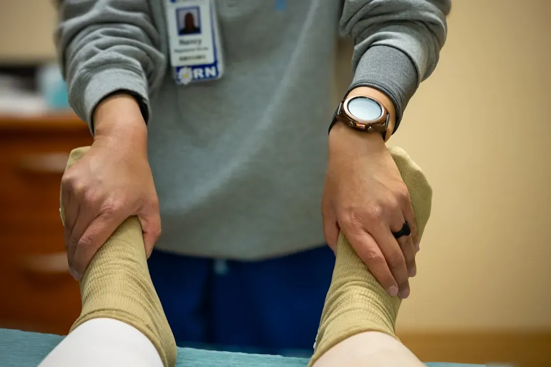 Mature adult receiving hands-on knee joint therapy in clinical setting, demonstrating physical rehabilitation techniques for 